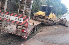 Caminhão que carregava trator colide contra barranco na BR-282