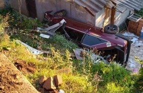 Carro para em pátio de residência após despencar de barranco