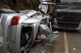 Colisão entre carro e carreta deixa jovem preso às ferragens
