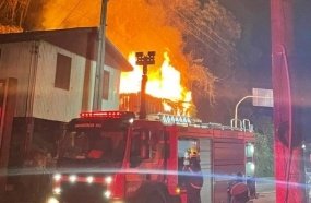 Bombeiros combatem incêndio em casa de madeira 