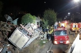 Motorista morre após caminhão tombar e invadir casa 