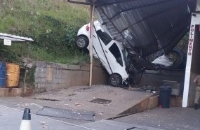 Veículo atinge cobertura de posto após despencar em barranco