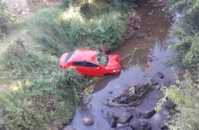 Carro despenca em barranco e vai parar dentro de rio 