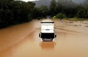 Motorista de carreta fica ilhado ao tentar passar por trevo inundado