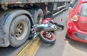 Motociclista fica ferido após colidir contra carro e carreta  