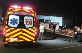 Jovem capota carro em estacionamento de posto de combustível 