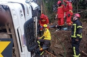 Socorristas levam mais de 2 horas para resgatar motorista de caminhão tombado 