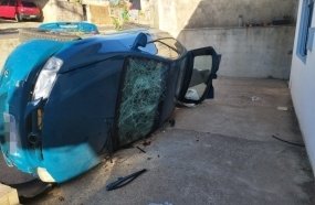 Mulher fica presa às ferragens após carro tombar em pátio de residência