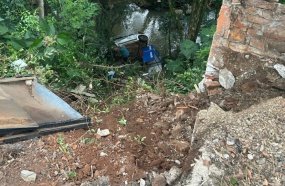 Carro cai em riacho após sair da pista e despencar em barranco