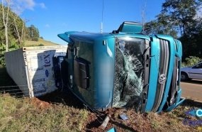Motorista fica ferido após carreta com contêiner tombar em curva