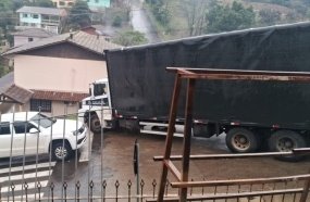 Erro de rota faz caminhão derrapar e colidir contra muro em Luzerna