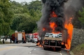 Duas pessoas morrem após caminhão com madeira tombar e pegar fogo na BR-282