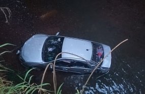 Veículo ocupado por três pessoas cai em rio após sair da pista 
