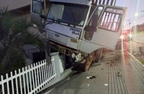 Caminhão fica encavalado em cerca de residência após desandar sozinho