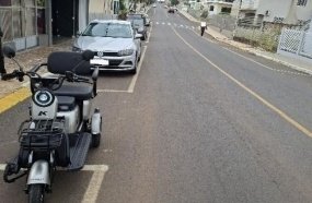 Mulher fica ferida após colidir triciclo elétrico contra carro estacionado