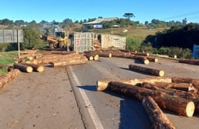 Carreta bitrem tomba e espalha toras na rodovia após colisão em Campos Novos