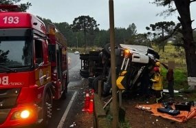 Motorista fica preso às ferragens após carreta tombar sobre defensa metálica 