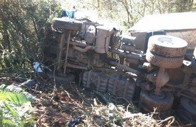 Carreta tenta ultrapassar trator, bate em caminhão e tomba em barranco